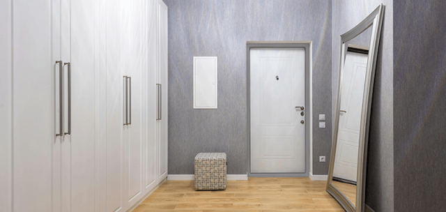 Bela vrata v moderni sivi sobi z belimi omarami